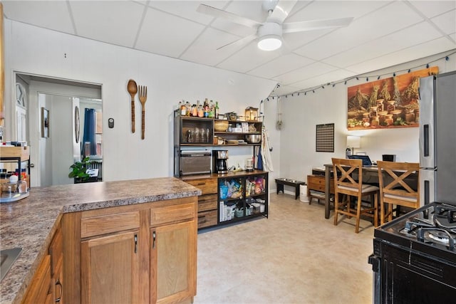 kitchen featuring a ceiling fan, light floors, and freestanding refrigerator