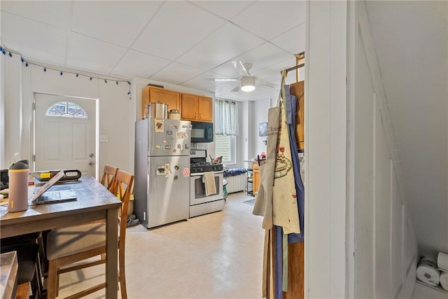 kitchen featuring light floors, stainless steel appliances, a paneled ceiling, and ceiling fan