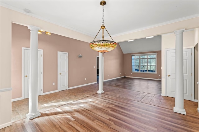 interior space featuring wood finished floors, baseboards, and decorative columns