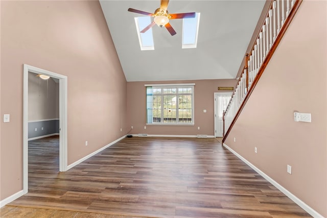 unfurnished living room with stairway, high vaulted ceiling, wood finished floors, and a ceiling fan