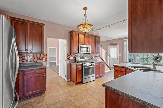 kitchen featuring a sink, backsplash, appliances with stainless steel finishes, and pendant lighting