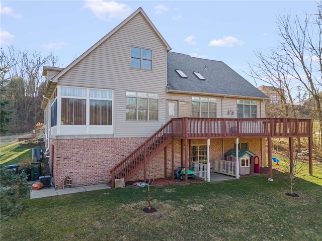 back of property with brick siding, stairway, a wooden deck, roof with shingles, and a yard