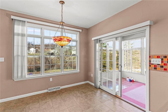 doorway to outside featuring tile patterned floors, visible vents, and baseboards