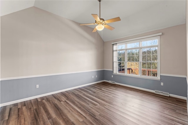 spare room featuring ceiling fan, visible vents, wood finished floors, and vaulted ceiling