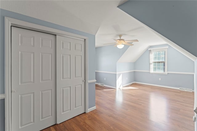 bonus room with visible vents, wood finished floors, baseboards, ceiling fan, and vaulted ceiling