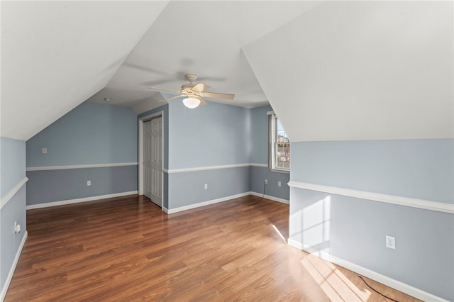 additional living space featuring lofted ceiling, wood finished floors, baseboards, and ceiling fan