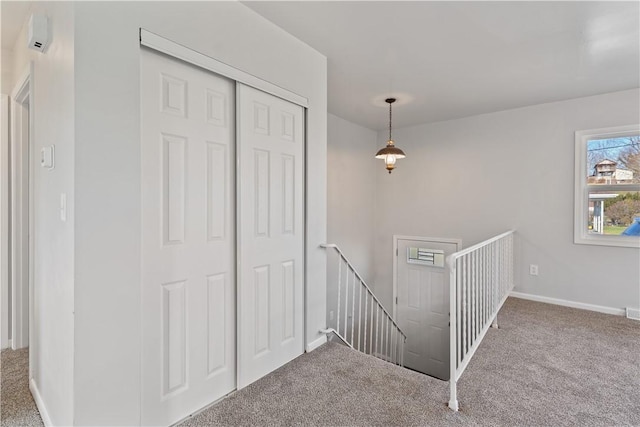 staircase featuring baseboards and carpet flooring