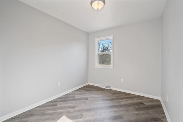 unfurnished room with visible vents, baseboards, and wood finished floors