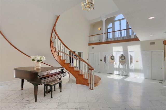 foyer entrance with baseboards, recessed lighting, stairs, a towering ceiling, and marble finish floor