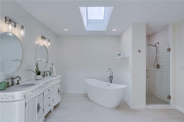 full bathroom featuring a sink, a skylight, and a shower stall