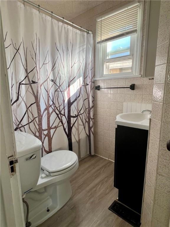 full bathroom featuring toilet, vanity, a shower with curtain, wood finished floors, and tile walls