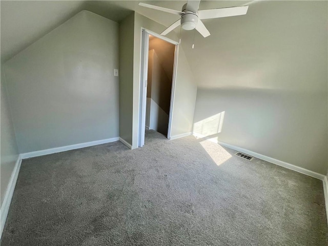 additional living space featuring carpet, baseboards, visible vents, ceiling fan, and vaulted ceiling