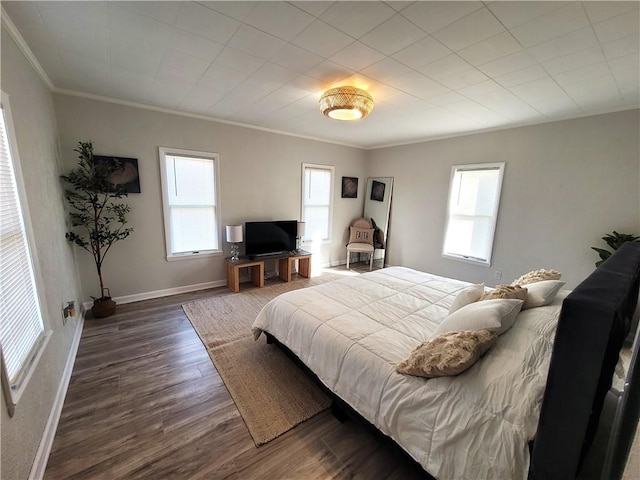 bedroom featuring crown molding, wood finished floors, and baseboards