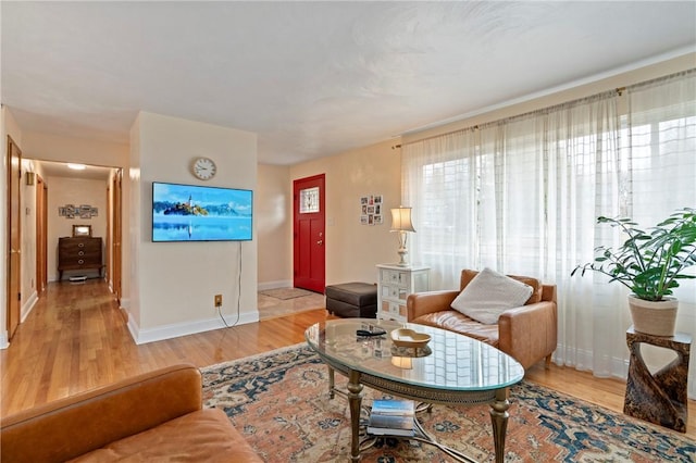 living area with baseboards and wood finished floors