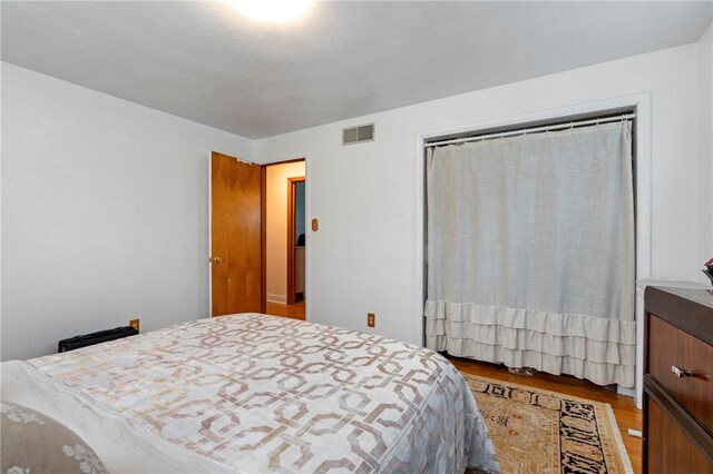 bedroom featuring visible vents and wood finished floors