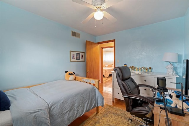 bedroom featuring visible vents, wood finished floors, and a ceiling fan