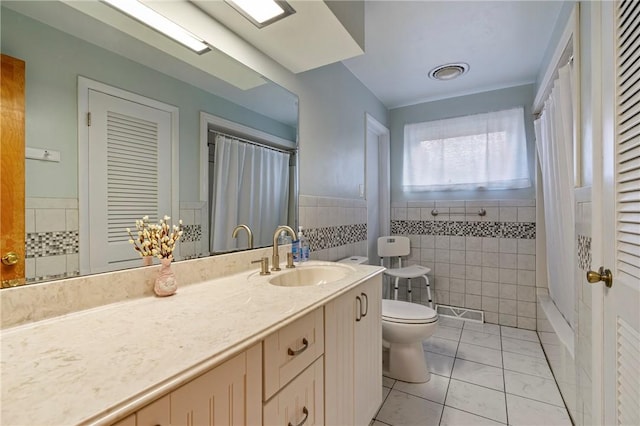 full bathroom featuring tile patterned floors, a wainscoted wall, toilet, tile walls, and vanity