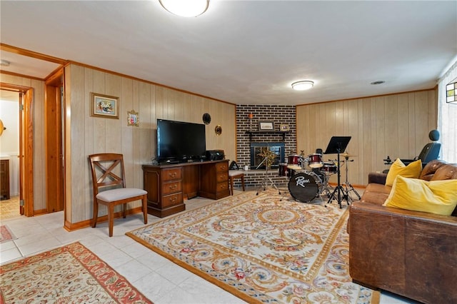 living room with wooden walls, a brick fireplace, light tile patterned flooring, and crown molding