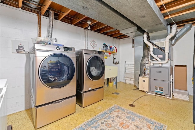 laundry area with washing machine and clothes dryer, laundry area, and concrete block wall