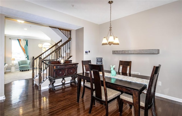 dining space featuring a notable chandelier, stairs, baseboards, and wood-type flooring