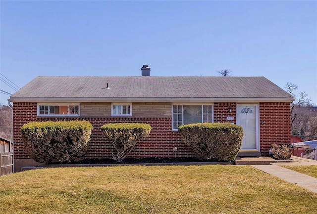 ranch-style house with a front yard, fence, brick siding, and a chimney