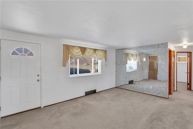 carpeted entrance foyer featuring visible vents