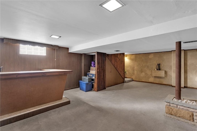 bar with a dry bar, wooden walls, baseboards, and light carpet