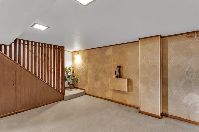 finished basement featuring carpet flooring, crown molding, and baseboards