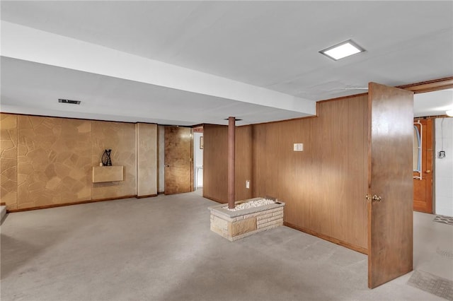 finished basement with carpet, baseboards, and wood walls