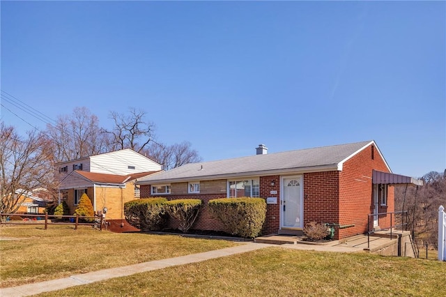 view of front of house featuring a front yard, fence, and brick siding