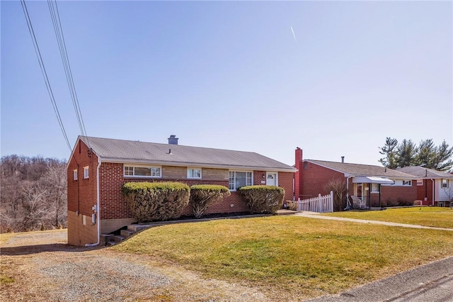 ranch-style home featuring a front lawn, fence, brick siding, and a chimney