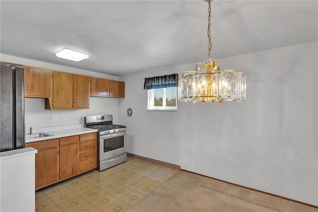 kitchen with stainless steel range with gas cooktop, a chandelier, light floors, light countertops, and a sink