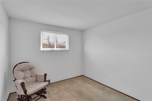 living area featuring baseboards and light carpet