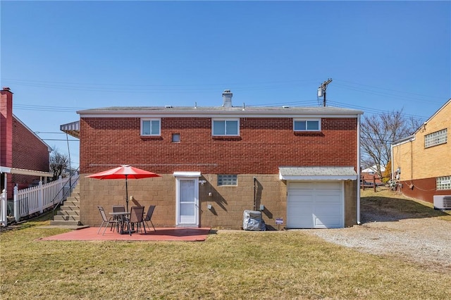 back of house with brick siding, a patio area, a garage, and fence