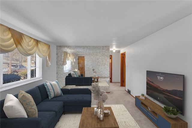 living area featuring an accent wall and light colored carpet