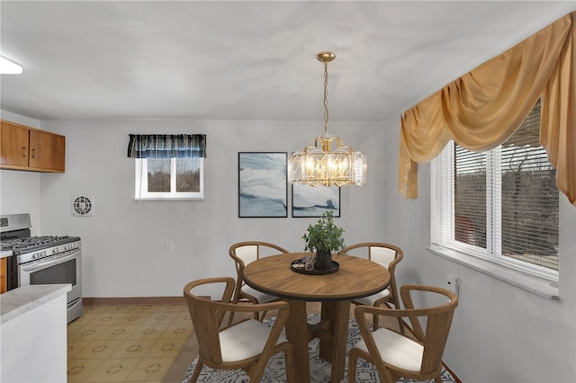 dining room with baseboards, light floors, and an inviting chandelier