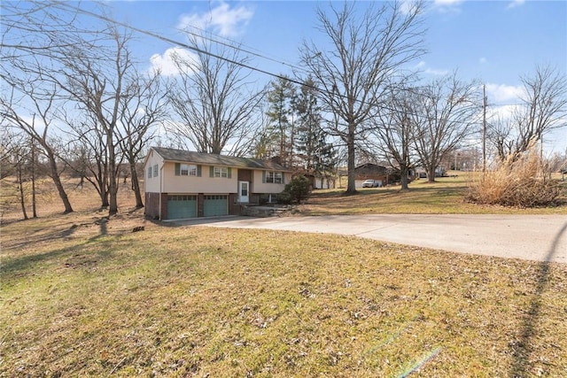 bi-level home with a front yard, a garage, and driveway