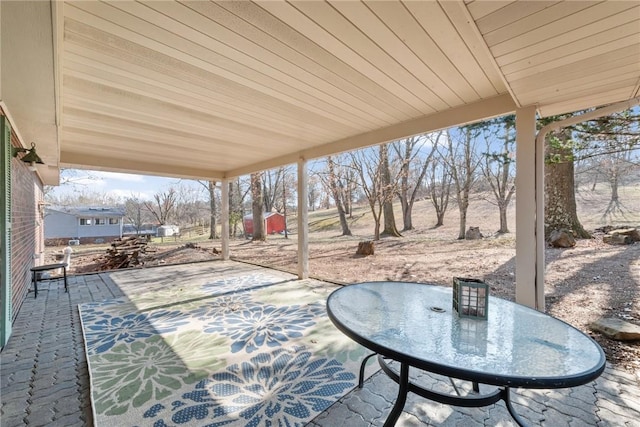 view of patio featuring outdoor dining area and an outbuilding