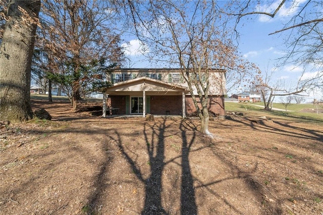 back of property featuring brick siding