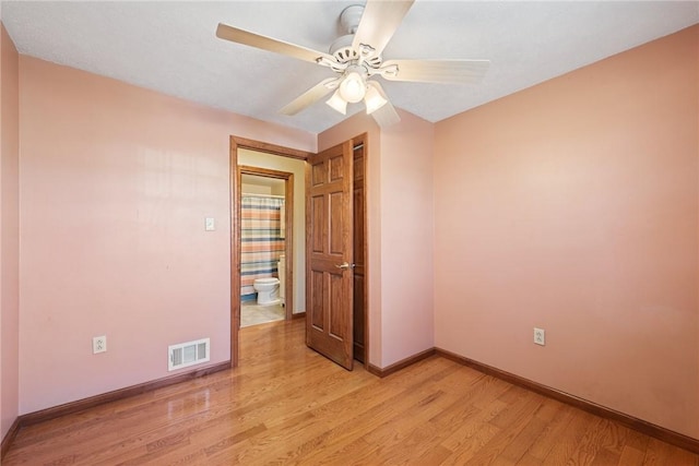 unfurnished room with visible vents, light wood-style flooring, baseboards, and ceiling fan