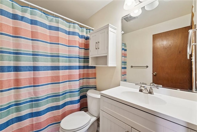 bathroom featuring a shower with shower curtain, visible vents, toilet, and vanity