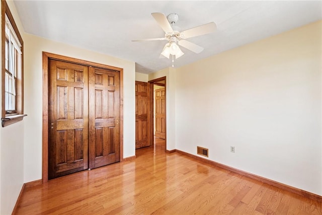 unfurnished bedroom featuring visible vents, light wood-style flooring, and baseboards