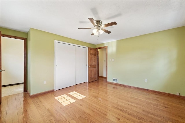 unfurnished bedroom featuring visible vents, a closet, light wood finished floors, baseboards, and ceiling fan