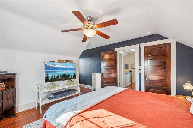 bedroom featuring baseboards, lofted ceiling, and wood finished floors