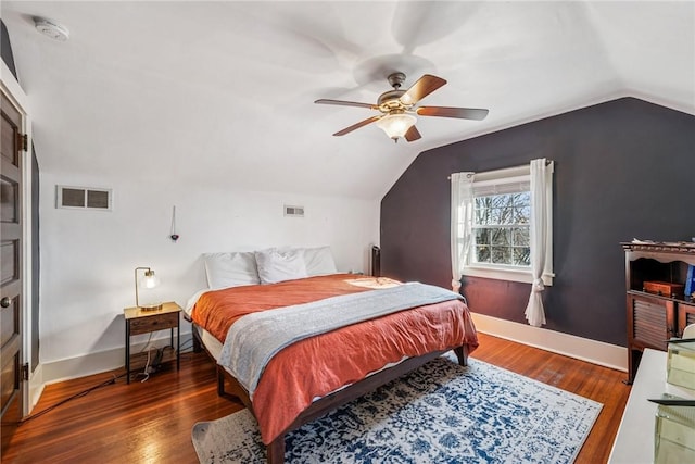 bedroom featuring visible vents, lofted ceiling, baseboards, and wood finished floors