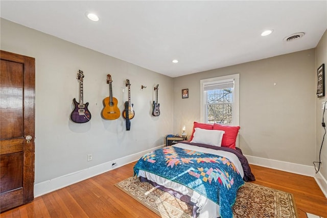 bedroom featuring recessed lighting, visible vents, baseboards, and wood finished floors