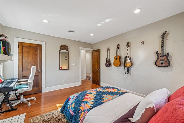 bedroom with recessed lighting, visible vents, baseboards, and wood finished floors