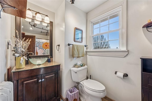 bathroom with radiator, toilet, and vanity