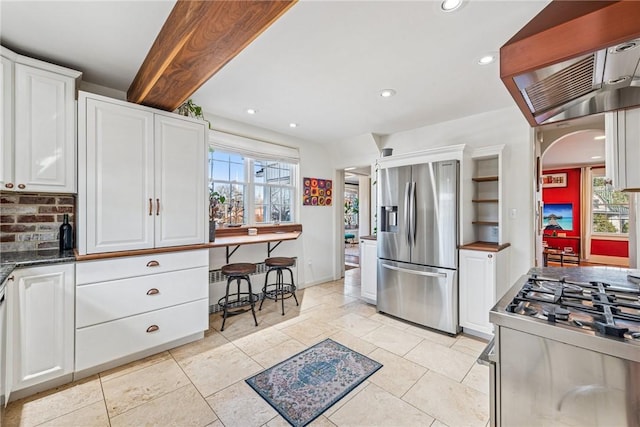 kitchen with white cabinets, recessed lighting, arched walkways, and stainless steel appliances