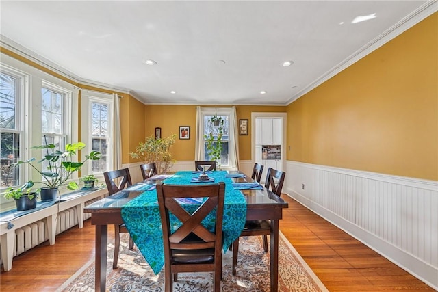 dining area with recessed lighting, light wood-type flooring, wainscoting, and crown molding